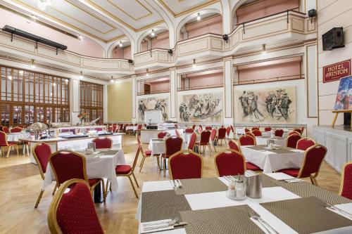 布拉格Hotel Patio Prague的用餐室配有桌椅,墙上挂有绘画作品