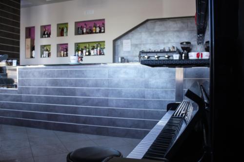 埃博利奥托梅佐住宿加早餐旅馆的一间酒吧,里面配有柜台和钢琴