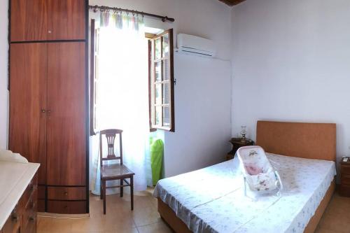 卡塔科隆Villa Galini的卧室配有床、椅子和窗户。