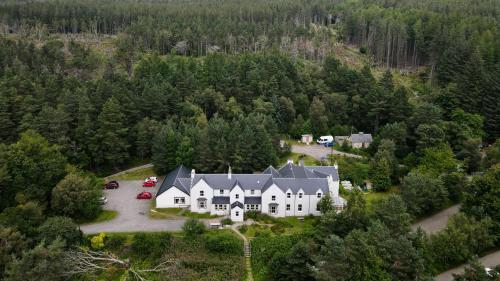 Loch MorlichCairngorm Lodge Youth Hostel的树林中一座大房子的空中景色