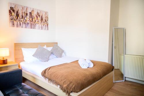 曼彻斯特Purple Blossom, cosy 2 bed apartment, near Didsbury, free parking的一间卧室配有一张床,上面有两条毛巾