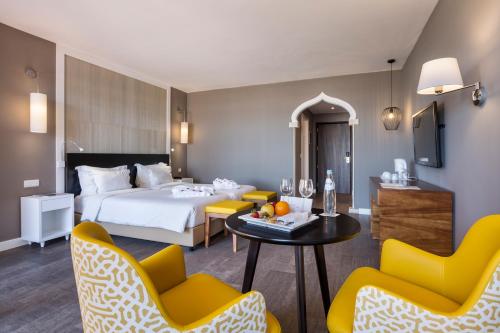 波尔蒂芒AP Oriental Beach - Adults Friendly的酒店客房带一张床、一张桌子和椅子