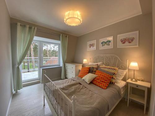 波别罗沃Apartamenty Silence Blue Baltic的一间卧室配有带橙色枕头的床和窗户。