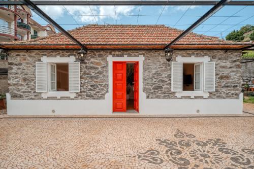 卡尼索Madeira Loft II - FREE CAR的红门和窗户的砖房