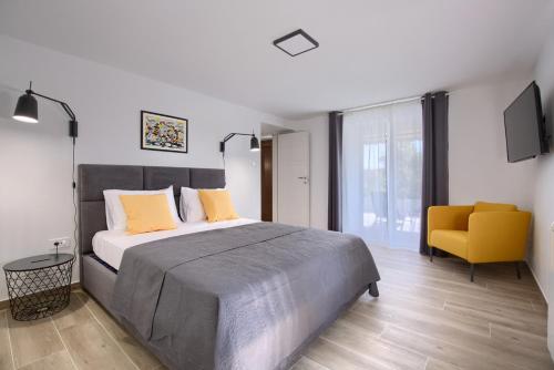 班约勒Apartment Marin 2 near the beach的一间卧室配有一张大床和一张黄色椅子