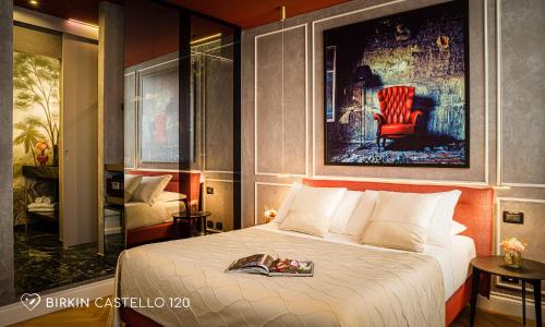 卡利亚里Albergo Diffuso Birkin Castello的酒店客房,配有一张床和一张红色椅子