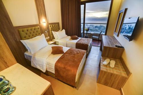 亚喀巴De-Lara hotel的酒店客房设有两张床和电视。