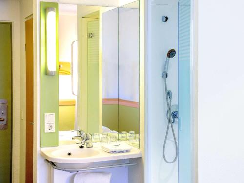奎克博恩宜必思汉堡奎克博恩快捷酒店的浴室配有盥洗盆和带镜子的淋浴