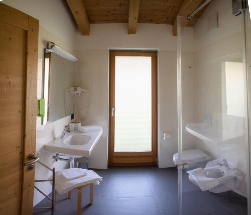 莱维科特尔梅Garnì Tuttotondo的一间带两个水槽和玻璃淋浴间的浴室