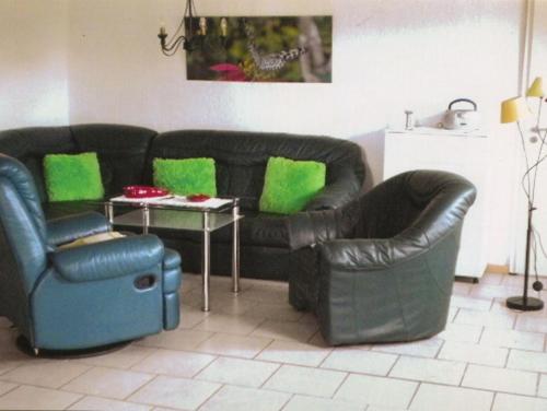 巴特Apartment Kenz-Küstrow的客厅配有黑色真皮沙发和桌子