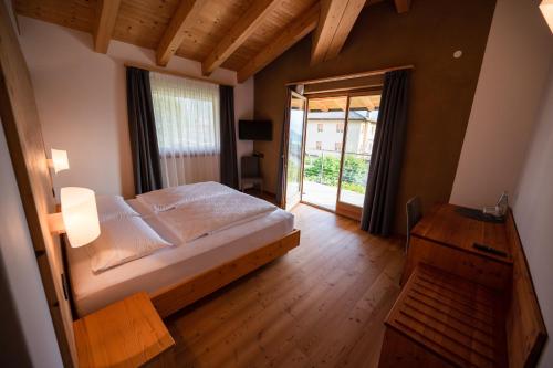 莱维科特尔梅Garnì Tuttotondo的一间卧室设有一张大床和一个大窗户