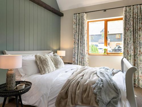 BramleyLantern Lodge的卧室配有白色的床和窗户。