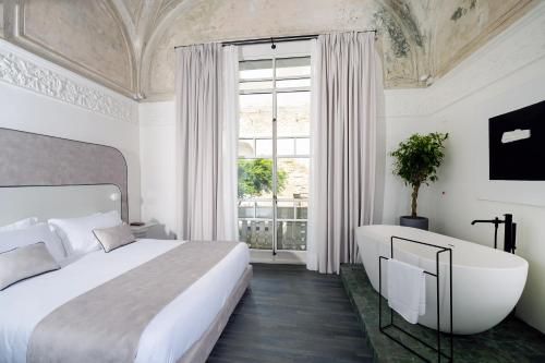 那不勒斯Artemisia Domus - Giardino的一间卧室设有一张床、浴缸和一个窗口