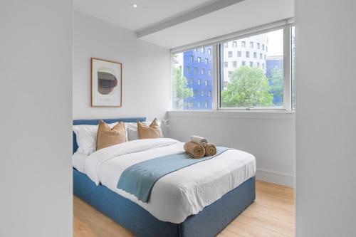 伦敦Livestay-Modern Apartments Next To Wembley Stadium的一间卧室设有一张大床和大窗户