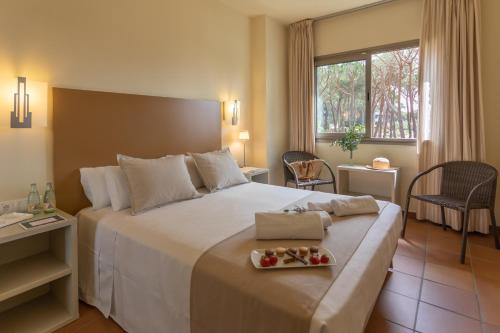 普拉加德阿罗帕洛尔城公寓式酒店的酒店客房设有一张大床,上面放着一盘食物