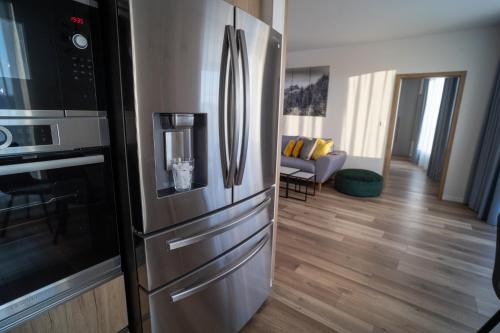 普雷绍夫Po City Newly Built Apartment的一间带不锈钢冰箱的厨房和一间客厅