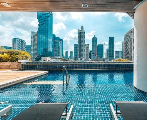 曼谷Pullman Bangkok Hotel G的一座城市天际线的游泳池