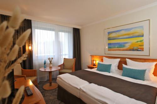 普雷罗Hotel Bernstein Prerow的酒店客房设有一张大床和一张桌子。