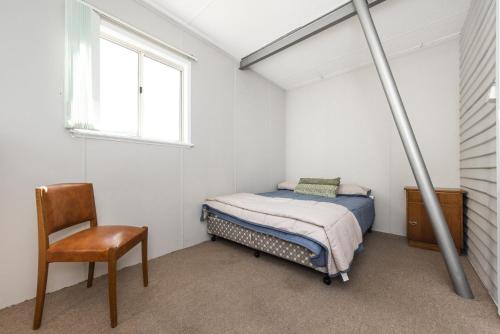 兰斯林The Cray Pot - Centre of it all的卧室配有床、椅子和窗户。