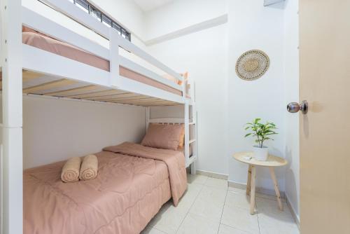 波德申PortDickson Cozy Muji Home 10Pax3BR 1min to beach的一间卧室配有一张床和一张双层床。