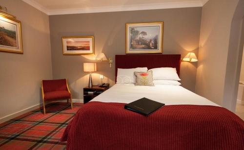 米尔盖Kirkhouse Inn的酒店客房,配有一张带红色毯子的床