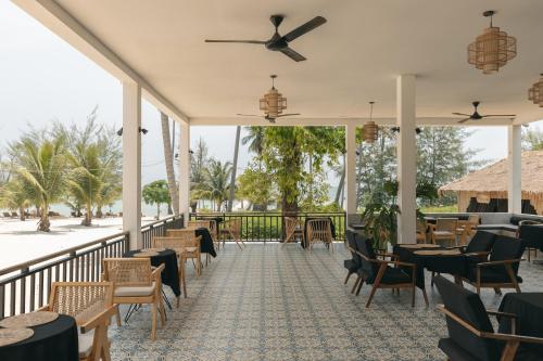 瓜隆岛Anaya Koh Rong的餐厅配有桌椅和吊扇