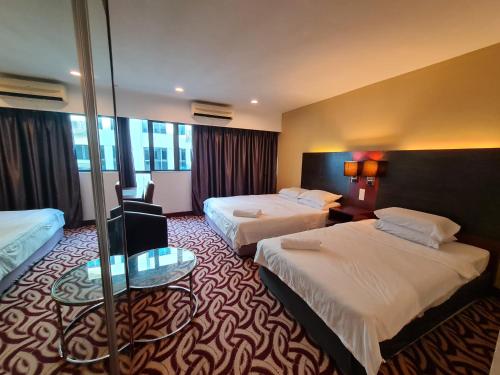 哥打京那巴鲁SUN GARDEN Studio and Residences at South China Sea Place Suites的酒店客房设有两张床和一张桌子。