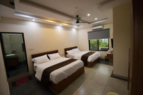 卡尔佩特塔ARAKKAL GUESTHOUSE的酒店客房设有两张床和窗户。