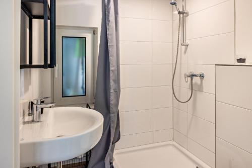 奎克博恩Tinyhouse Baumann的白色的浴室设有水槽和淋浴。