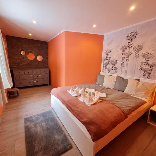 穆劳Murzeit Zweite的一间卧室配有一张带橙色墙壁的大床