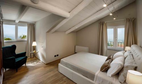 蒙福特达尔巴Villa Gremì - Monforte d'Alba的卧室配有一张白色大床和一把椅子