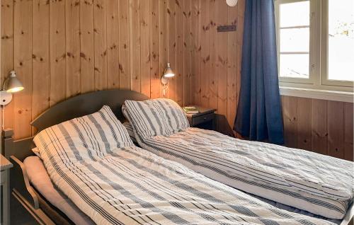 弗洛Beautiful Home In Fl With Sauna的卧室设有木墙,配有一张未铺砌的床。