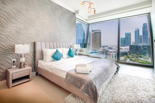 迪拜Burj Vista 08 3BR Burj & Fountain View的一间卧室设有一张大床和一个大窗户