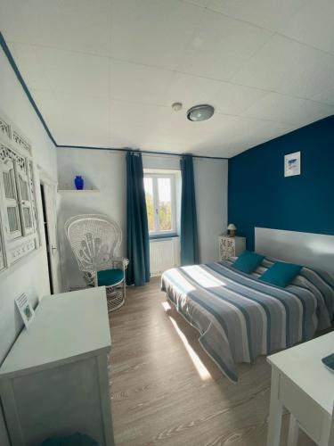 Saint-Sornin-LeulacLes forges de Planechaud的一间卧室拥有蓝色的墙壁,配有一张带蓝色枕头的床。