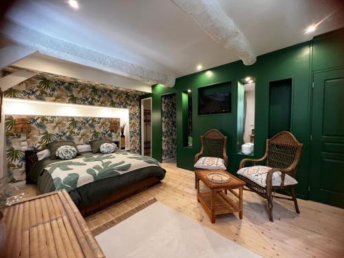 Saint-Féliu-dʼAvallLe Cèdre 1830 Maison d'hôtes de charme的一间卧室设有绿色的墙壁和一张床及椅子