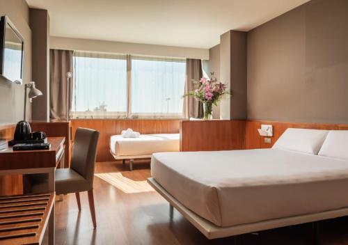 卡斯特尔德费尔斯SB BCN活动四星级高级酒店的配有一张床和一张书桌的酒店客房