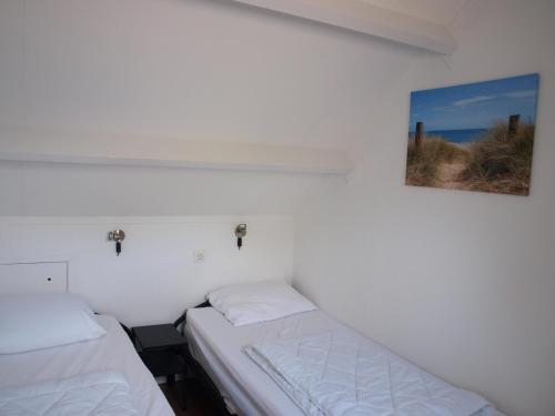 佐特兰德Appartement ,Vakantiewoning, Koddelaan 29的一间设有两张床的客房,墙上挂着一张照片