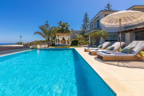古瓦伊Villa Ioulia Gouves的一个带躺椅和遮阳伞的游泳池