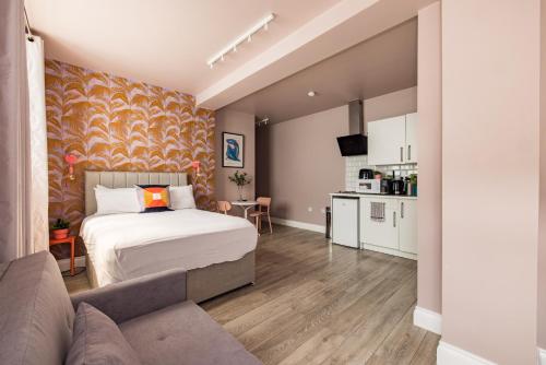 伦敦Euston apartments的一间卧室配有一张床和一张沙发,还设有一间厨房