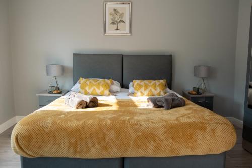 大雅茅斯Cozy House with Modern Garden的一间卧室配有一张大床和两条毛巾