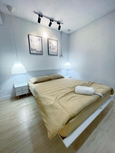 Kampong Haji MusaKota Bharu RS Desa Roomstay的白色房间中的一张大床,配有两盏灯