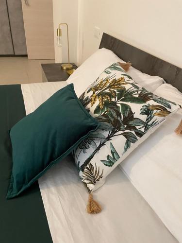 拉奎拉B & B Piazza Angioina的一张带绿色和白色枕头的床