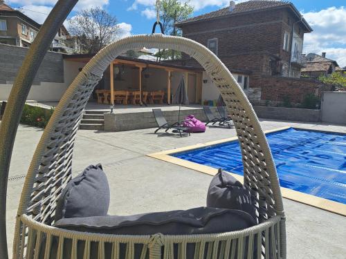 IlindentsiSunset view guest house的游泳池前的吊床椅