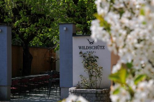 旧明斯特Aktivhotel Wildschütz的餐厅的标志,带桌椅