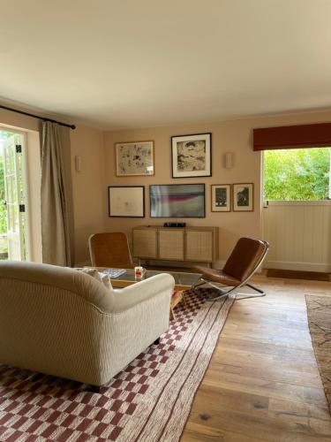 海尔舍姆Peaceful cottage with private garden的客厅配有沙发、椅子和电视