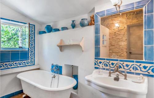 拉科斯特Lovely Home In Lacoste With Kitchen的蓝色和白色的浴室设有浴缸和水槽
