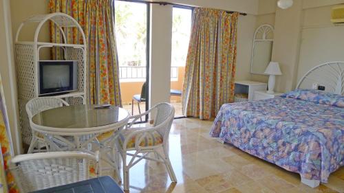 璜多里奥美丽殿酒店的卧室配有一张床和一张桌子及椅子