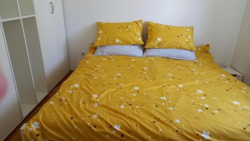 阿然德洛维克Domaćinska kuća的一张带黄色被子和枕头的床