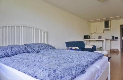 巴特莱辛哈尔Appartement Traumblick的一间卧室配有一张带蓝色被子和椅子的床