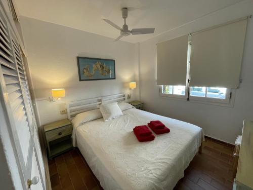 福尔内利斯ES CASTELL 1 6 by SOM Menorca的一间卧室配有一张带两个红色枕头的床